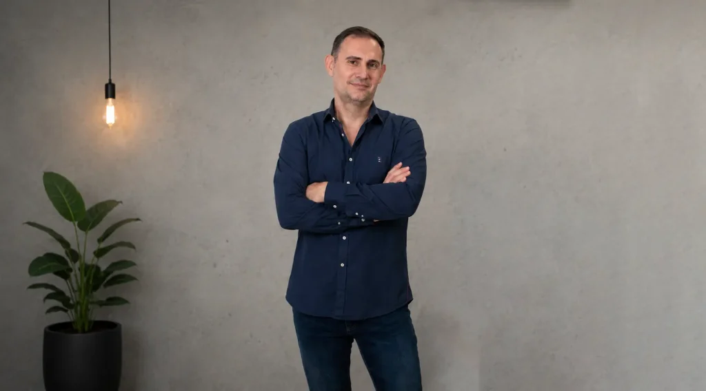 Consultor SEO local de SEO de Barrio de pie con los brazos cruzados frente a una pared de hormigón